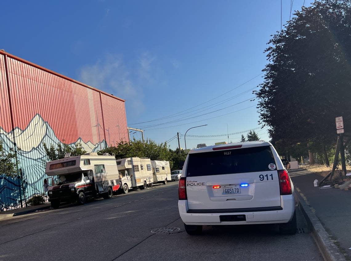Bellingham Police officers are parked near several RVs on Cornwall Avenue on Aug. 15, as a Public Works Department crew picked up trash near the encampment.