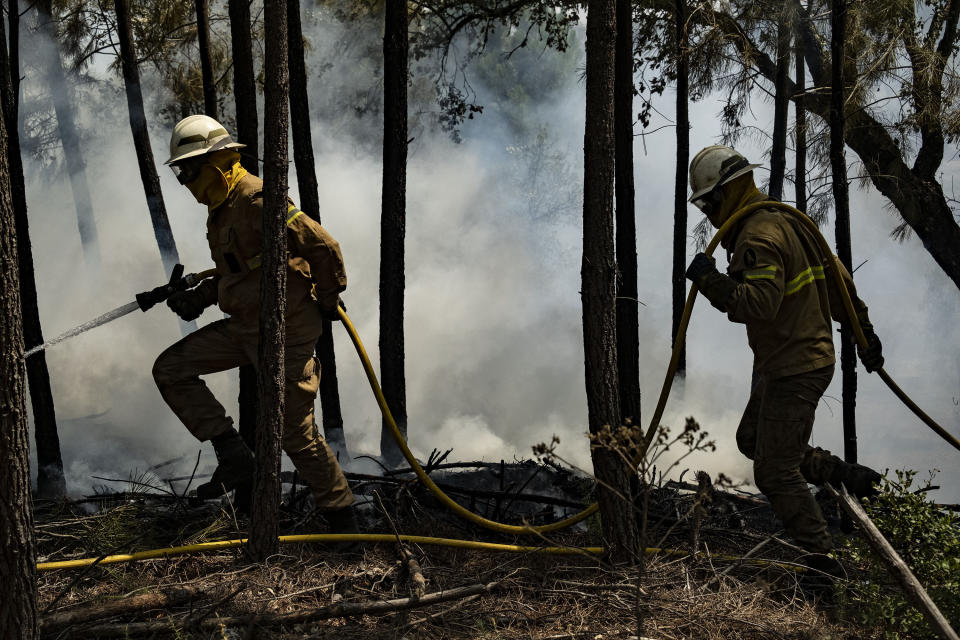 Firefighters try to extinguish a wildfire near Colos village, in central Portugal on Monday, July 22, 2019. More than 1,000 firefighters battled Monday in torrid weather against a major wildfire in Portugal, where every summer forest blazes wreak destruction. (AP Photo/Sergio Azenha)