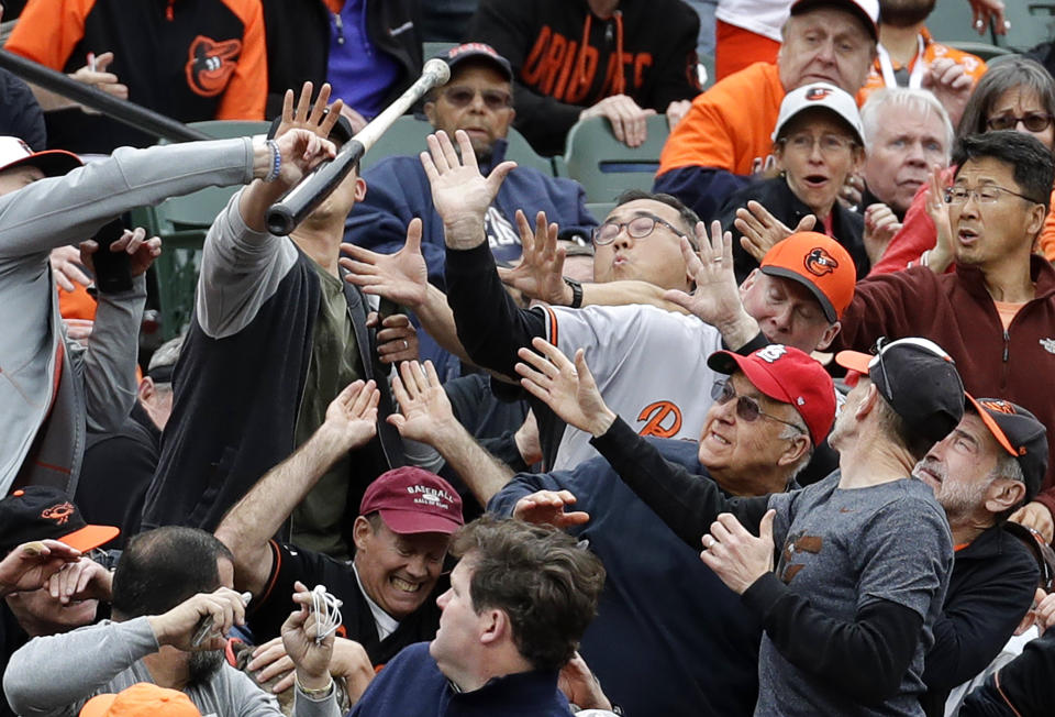 Fans react as a bat flies into the stands after Toronto Blue Jays' Kevin Pillar lost his grip during an at-bat in the eighth inning of an opening day baseball game against the Baltimore Orioles in Baltimore, Monday, April 3, 2017. Baltimore won 3-2 in 11 innings. (AP Photo/Patrick Semansky)