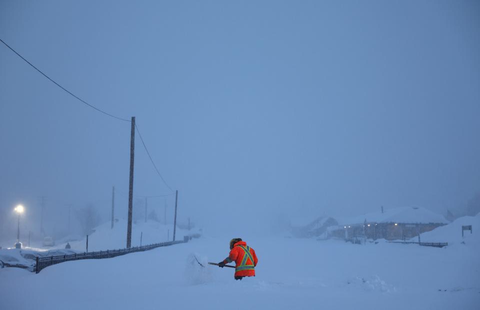 A Union Pacific worker shovels snow near the railroad tracks during a powerful multiple day winter storm in the Sierra Nevada mountains on Saturday in Truckee, California.