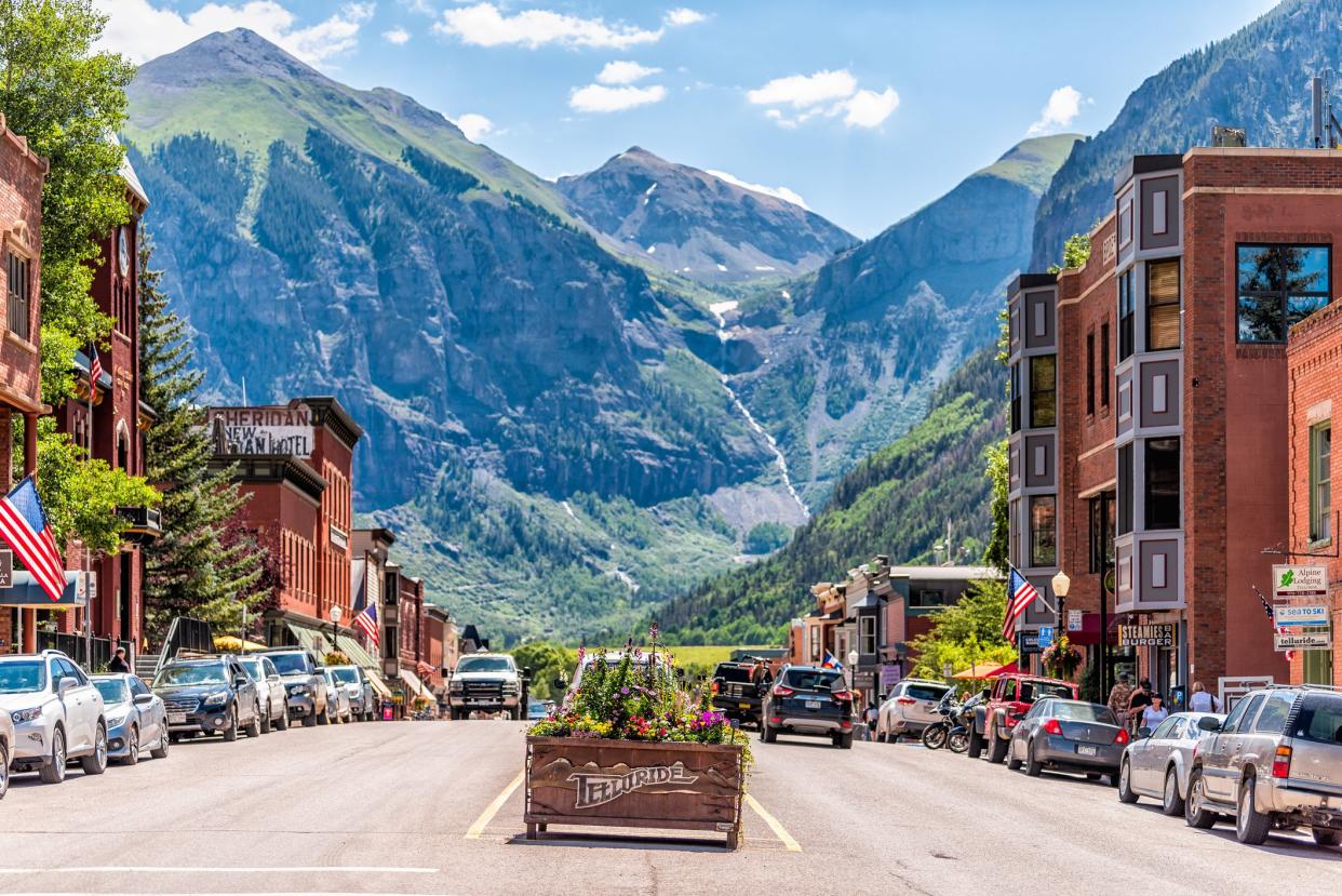 Telluride, USA - August 14, 2019: Small town village in Colorado with sign for city and flowers by historic architecture on main street mountain view
