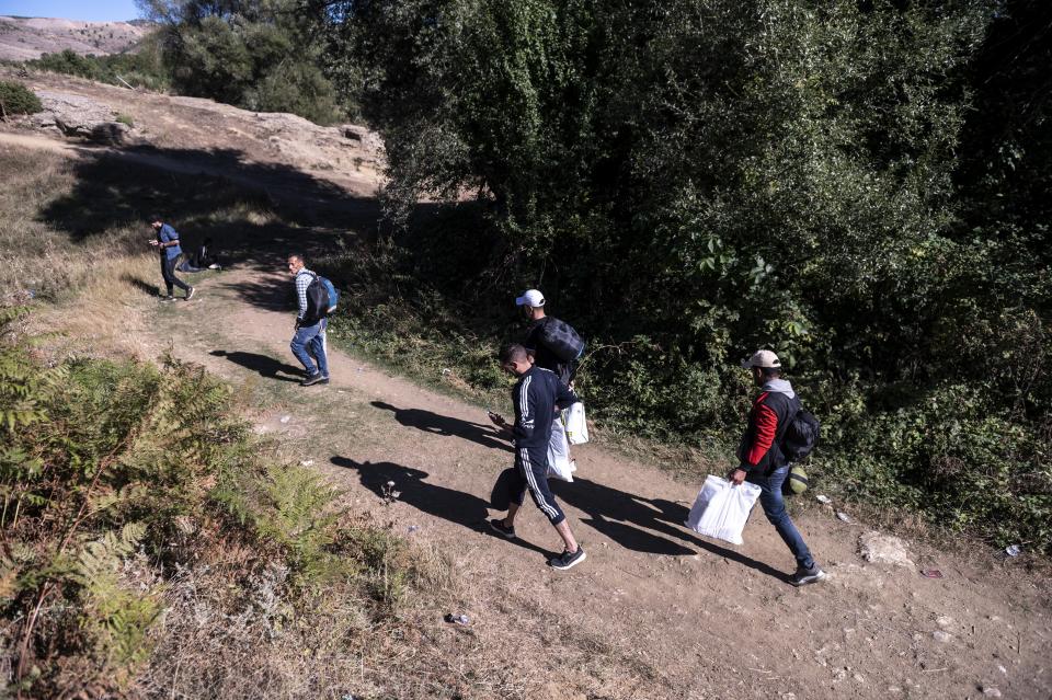 Migrants arrive at an abandoned army outpost near Ieropigi village, northern Greece, at the Greek - Albanian border, on Saturday, Sept. 25, 2021. A relatively smooth section of Greece's rugged border with Albania is turning into a major thoroughfare north for migrants in Greece seeking a better life in Europe's prosperous heartland. (AP Photo/Giannis Papanikos)