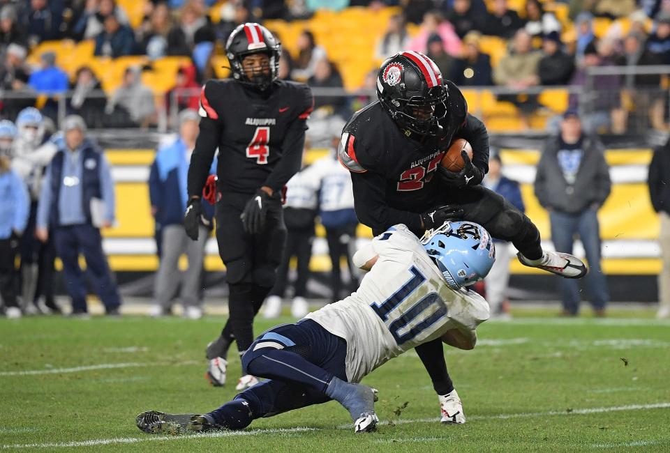 Tiqwai Hayes #23 of the Aliquippa Quips is wrapped up for a tackle by Bret Fitzsimmons #10 of the Central Valley Warriors in the first half during the WPIAL Class 4A championship game at Acrisure Stadium on November 25, 2022 in Pittsburgh, Pennsylvania.