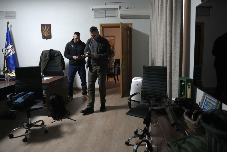 Vitali Klitschko, Kyiv Mayor and former heavyweight champion, right, and his brother Wladimir Klitschko, a Ukrainian former professional boxer look their smart phones in the City Hall in Kyiv, Ukraine, Sunday, Feb. 27, 2022. A Ukrainian official says street fighting has broken out in Ukraine's second-largest city of Kharkiv. Russian troops also put increasing pressure on strategic ports in the country's south following a wave of attacks on airfields and fuel facilities elsewhere that appeared to mark a new phase of Russia's invasion. (AP Photo/Efrem Lukatsky)