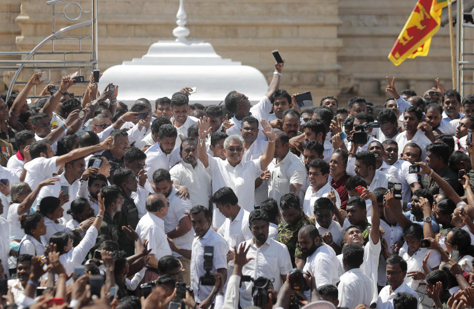 Sri Lanka's newly elected president Gotabaya Rajapaksa, center, greets people as he leaves after the swearing in ceremony held at the 140 B.C Ruwanweli Seya Buddhist temple in ancient kingdom of Anuradhapura in north central Sri Lanka Monday, Nov. 18, 2019. The former defense official credited with ending a long civil war was Monday sworn in as Sri Lanka’s seventh president after comfortably winning last Saturday’s presidential election. (AP Photo/Eranga Jayawardena)