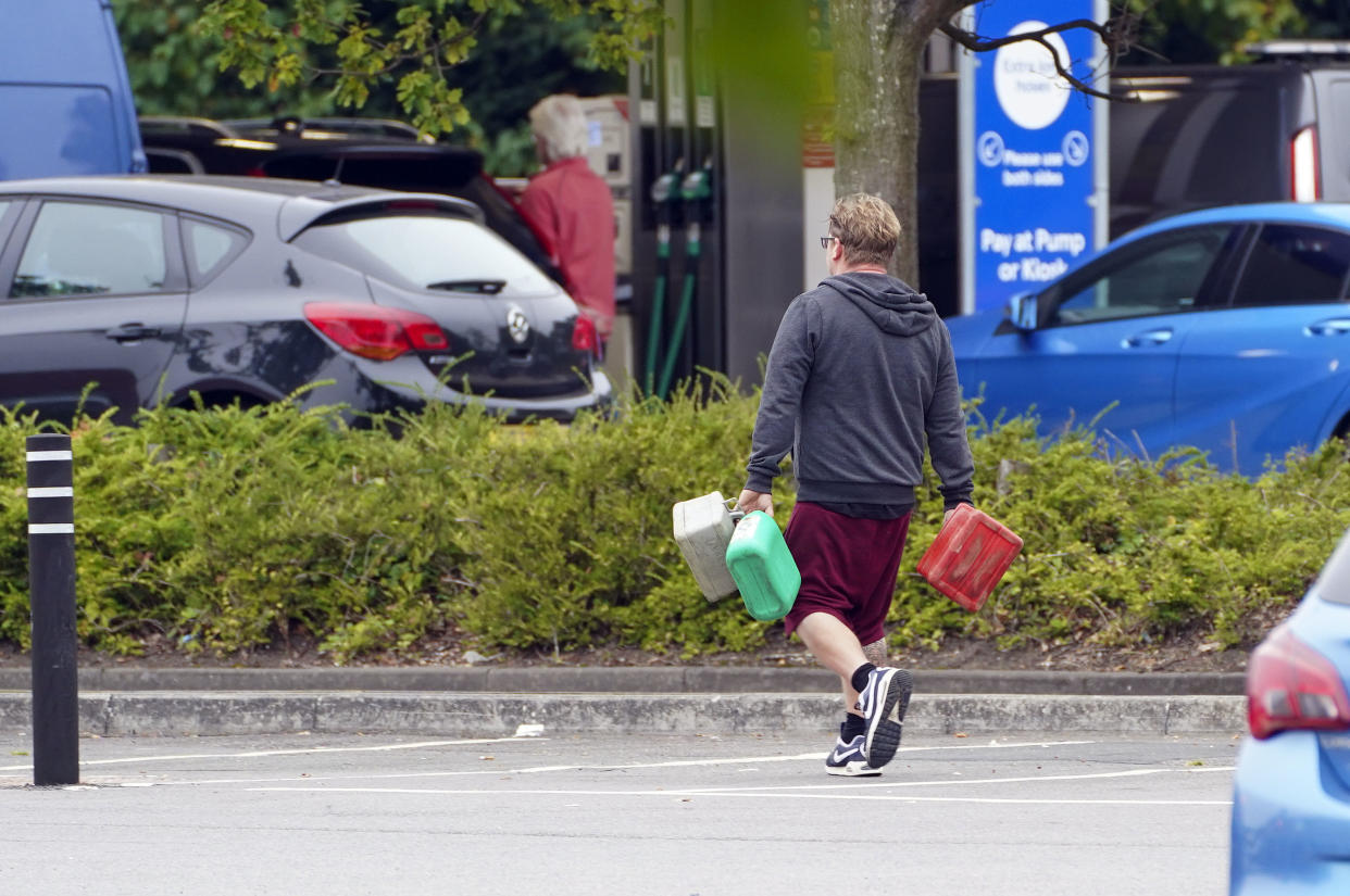 A man carrying containers at a Tesco Petrol Station in Bracknell, Berkshire. Picture date: Saturday September 25, 2021. (Photo by Steve Parsons/PA Images via Getty Images)