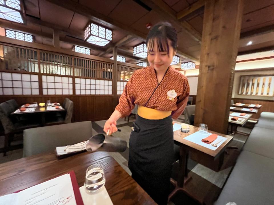 server pouring water into casey's glass at Takumi-Tei in epcot at disney world