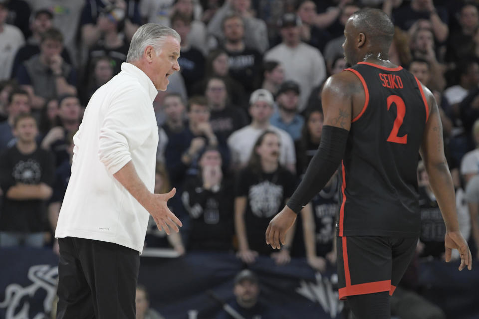 San Diego State coach Brian Dutcher talks to guard Adam Seiko (2), who had been called for a technical foul against Utah State during the second half of an NCAA college basketball game Wednesday, Feb. 8, 2023, in Logan, Utah. (AP Photo/Eli Lucero)