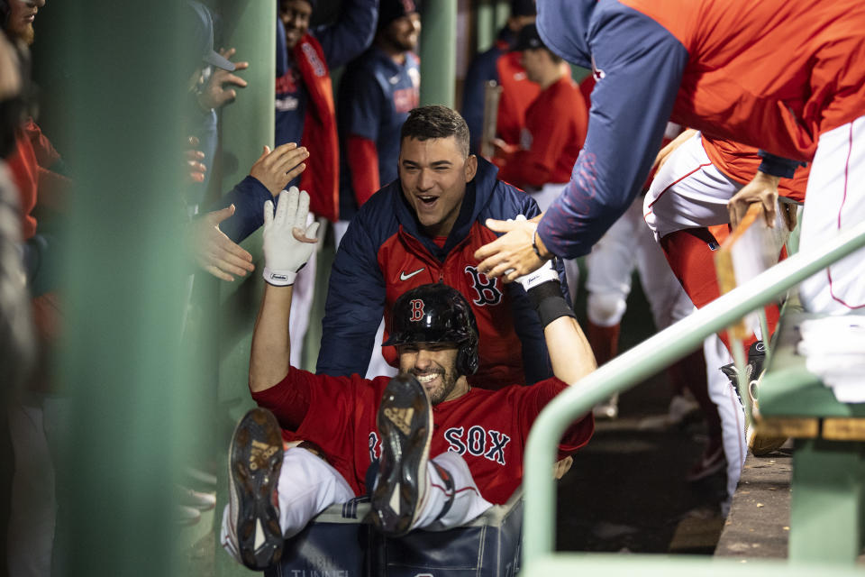 Jose Iglesias pushes J.D. Martinez in a laundry cart through a celebratory gauntlet in the dugout, part of the customary Red Sox home run celebration.