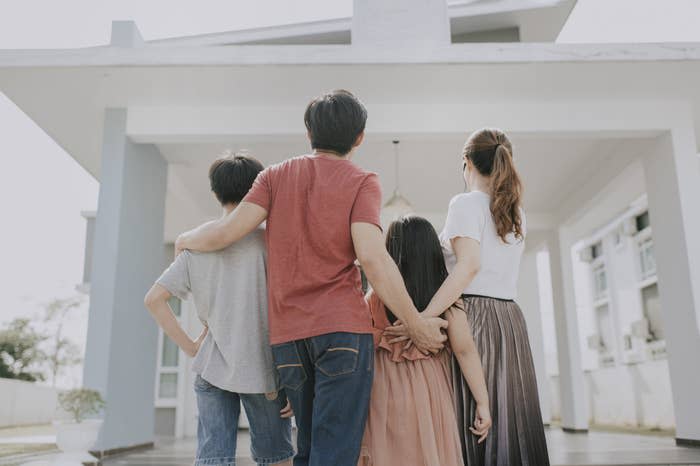 A family standing outside of their new home