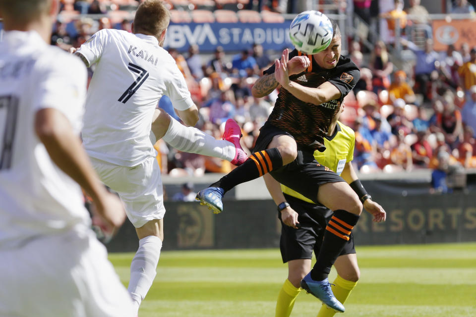 Los Angeles Galaxy midfielder Aleksandar Katai (7) kicks the ball into Houston Dynamo midfielder Matías Vera, right, during the first half of an MLS soccer match Saturday, Feb. 29, 2020, in Houston. (AP Photo/Michael Wyke)