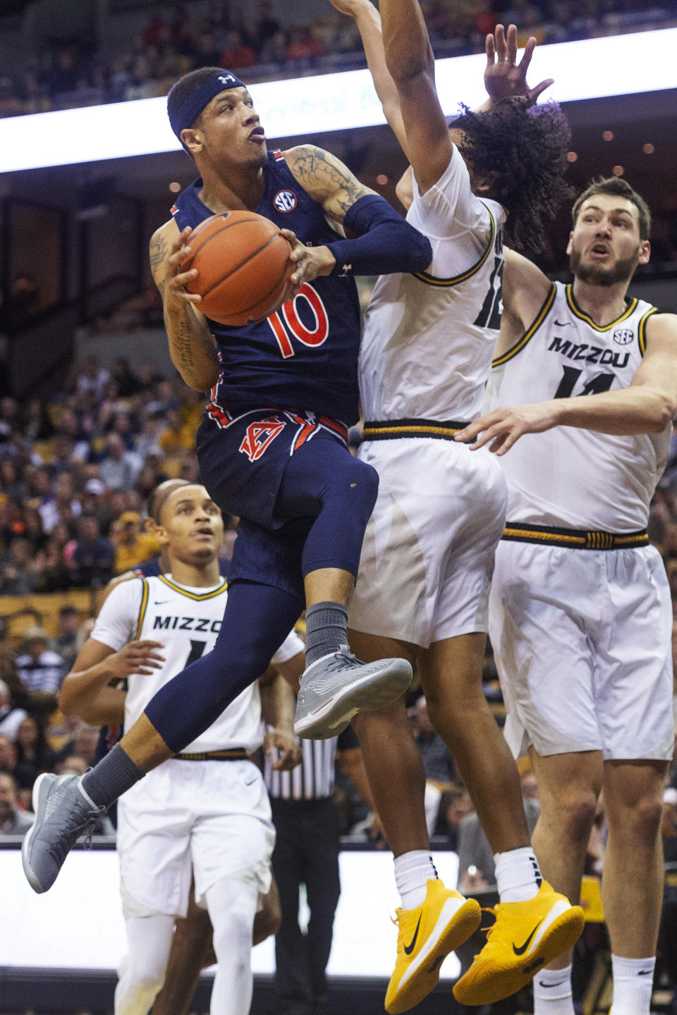 Auburn's Samir Doughty, left, shoots past Missouri's Dru Smith, center, and Reed Nikko, right, during the first half of an NCAA college basketball game Saturday, Feb. 15, 2020, in Columbia, Mo. (AP Photo/L.G. Patterson)