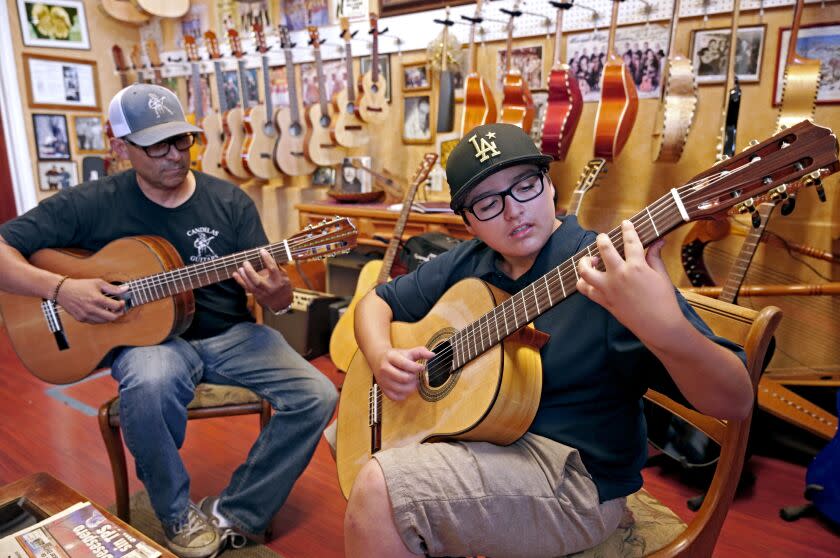 Candelas Guitars owner Tomas Delgado, left, keeps an eye on student Eloy González