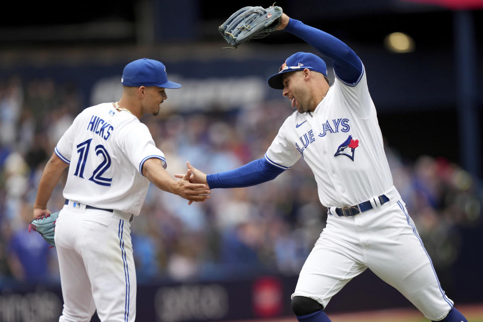 Toronto Blue Jays' George Springer (4) celebrates with teammate Jordan Hicks (12) after beating the Kansas City Royals in a baseball game, Saturday, Sept. 9, 2023, in Toronto. (Nathan Denette/The Canadian Press via AP)