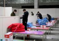 Workers set up infrastructure at the Wuhan International Conference and Exhibition Center to convert it into a makeshift hospital to receive patients infected with the new coronavirus, in Wuhan