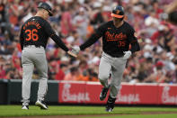 Baltimore Orioles' Adley Rutschman, right, celebrates with third base coach Tony Mansolino, left, as he rounds the bases after hitting a home run in the fifth inning of a baseball game against the Cincinnati Reds, Saturday, May 4, 2024, in Cincinnati. (AP Photo/Carolyn Kaster)