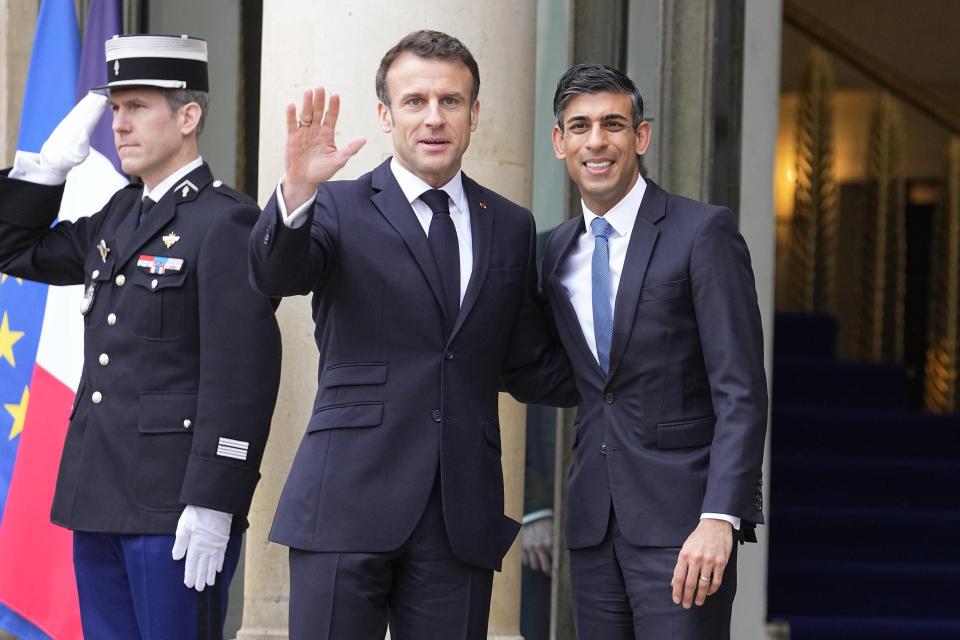 French President Emmanuel Macron, center, welcomes Britain's Prime Minister Rishi Sunak Friday, March 10, 2023 at the Elysee Palace in Paris. French President Emmanuel Macron and British Prime Minister Rishi Sunak meet for a summit aimed at mending relations following post-Brexit tensions, as well as improving military and business ties and toughening efforts against Channel migrant crossings. (AP Photo/Michel Euler)
