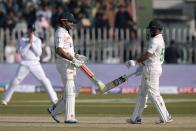 Pakistan's Babar Azam, center, celebrates with teammate Saud Shakeel, right, after hitting a boundary during the third day of the first test cricket match between Pakistan and England, in Rawalpindi, Pakistan, Saturday, Dec. 3, 2022. (AP Photo/Anjum Naveed)