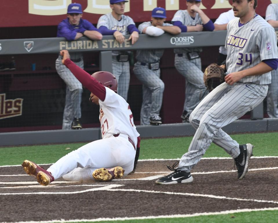 Florida State's DeAmez Ross (left) scores the first runs of the Seminoles' baseball season on opening day against James Madison on Feb. 17, 2023, at Dick Howser Stadium.