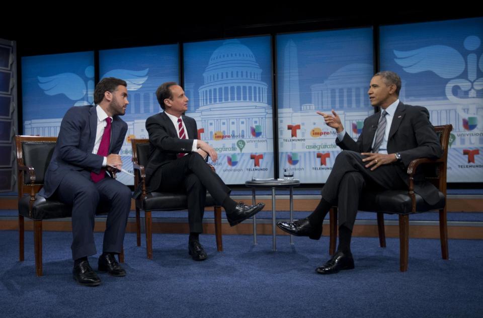 President Barack Obama talks with television hosts Jose Diaz Balart, center, and Enrique Acevedo, left, during a town hall event on the importance of the benefits of the Affordable Care Act for Hispanic community, Thursday, March 6, 2014, at the Newseum in Washington. (AP Photo/Pablo Martinez Monsivais)