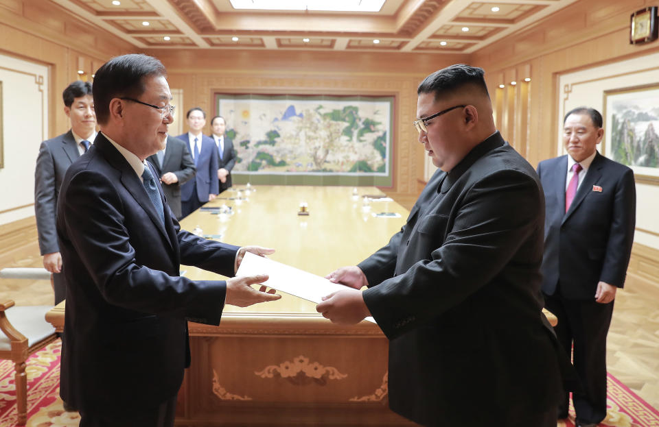 In this Wednesday, Sept. 5, 2018 photo provided on Thursday, Sept. 6, 2018 by South Korea Presidential Blue House via Yonhap News Agency, North Korean leader Kim Jong Un receives the letter from South Korean President Moon Jae-in from South Korean National Security Director Chung Eui-yong, left, in Pyongyang, North Korea. A South Korean delegation met with North Korean leader Kim Jong Un on Wednesday during a visit to arrange an inter-Korean summit planned for this month and help rescue faltering nuclear diplomacy between Washington and Pyongyang. (South Korea Presidential Blue House/Yonhap via AP)