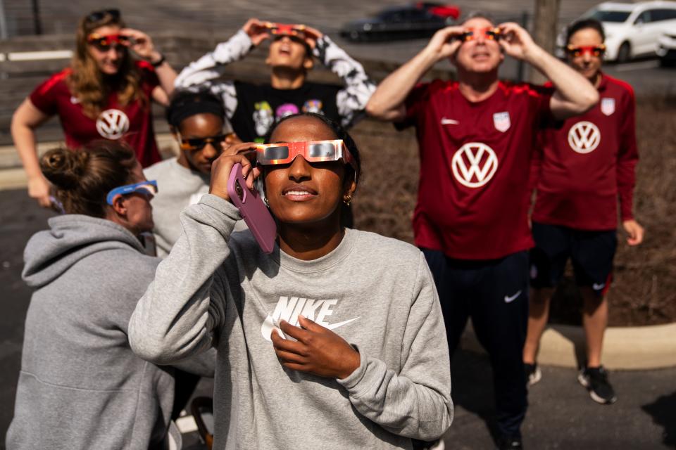 Naomi Girma, a center back for the U.S. women’s national soccer team, takes a peak at the solar eclipse with her teammates and staff as it passes over Columbus, Ohio, at 99% totality Monday, April 8, 2024.