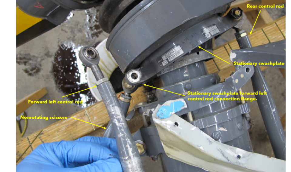 This NTSB photo shows the helicopter’s disconnected forward left control rod from the stationary swash plate.