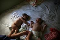 Five-month-old twins Laura (R) and Lucas lie on a bed at their house in Santos, Sao Paulo state, Brazil April 20, 2016. REUTERS/Nacho Doce