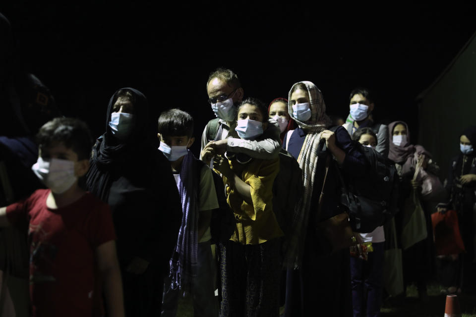 Evacuated citizens from Afghanistan arrive at Tirana International Airport in Tirana, Albania, Friday, Aug. 27, 2021. A government decision has planned that the Afghans may stay at least a year during which they will proceed with their application for special visas before they move on to the U.S. for final settlement. (AP Photo/Franc Zhurda)