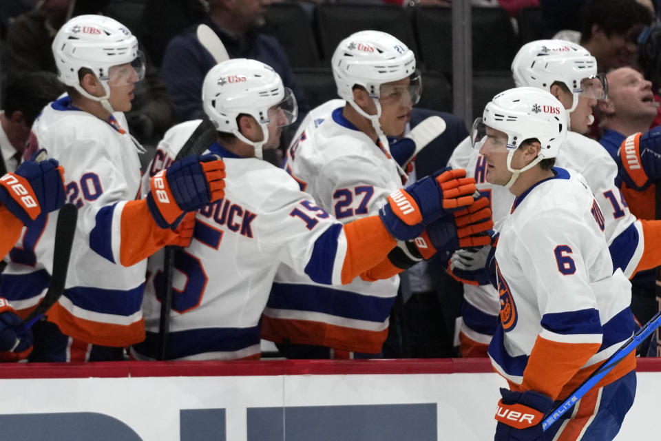 New York Islanders defenseman Ryan Pulock (6) celebrates with teammates, from left to right, right wing Hudson Fasching, right wing Cal Clutterbuck and left wing Anders Lee after scoring in the first period of an NHL hockey game against the Washington Capitals, Thursday, Nov. 2, 2023, in Washington. (AP Photo/Mark Schiefelbein)