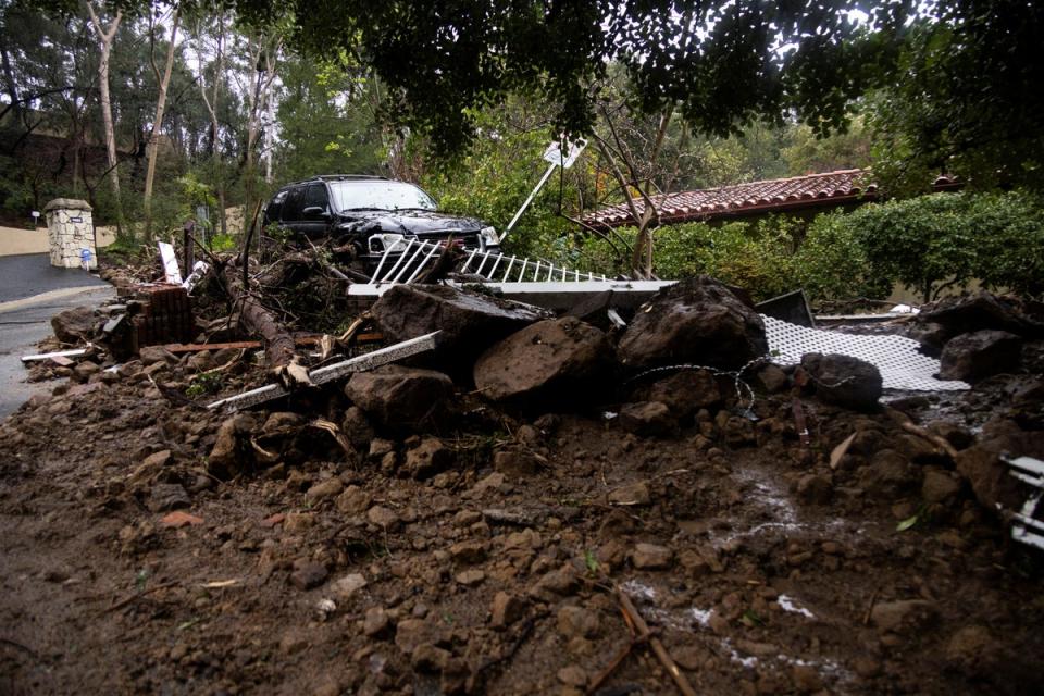 A car sits on top of a pile of debris during a rain storm in Studio City, California (REUTERS)