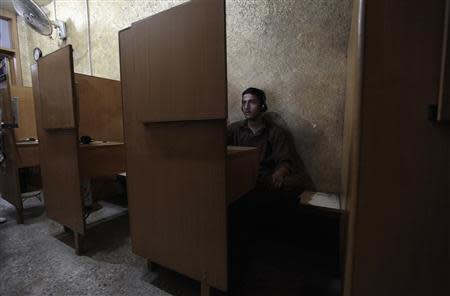 A man sits at an internet cafe in Rawalpindi September 17, 2013. REUTERS/Faisal Mahmood