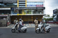 Policemen check the credentials of commuters during a lockdown imposed to curb the spread of coronavirus in Kochi, Kerala state, India, Saturday, May 8, 2021. Kerala, which emerged as a blueprint for tackling the pandemic last year, began a lockdown on Saturday. (AP Photo/R S Iyer)