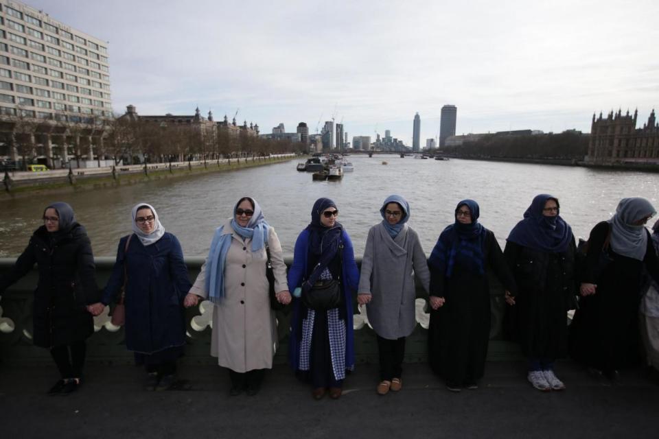 Tribute: Women activists wearing blue hold hands on Westminster Bridge in front of the Houses of Parliament to honour the victims of the March 22 attack (AFP/Getty Images)