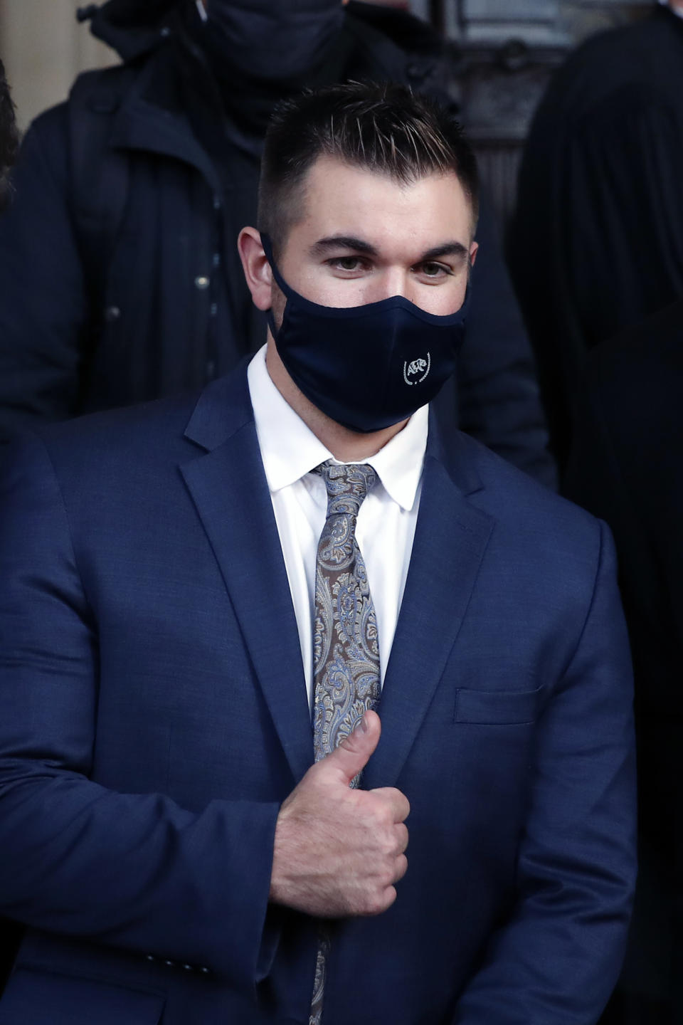 Alek Skarlatos gives a thumb up at the end of his hearing during the Thalys attack trial at the Paris courthouse, Friday, Nov. 20, 2020. Passengers who wrestled and disarmed an Islamic State gunman aboard a high-speed Amsterdam to Paris train are recounting how their split-second decisions helped prevent what could have become a mass slaughter. AP Photo/Francois Mori)