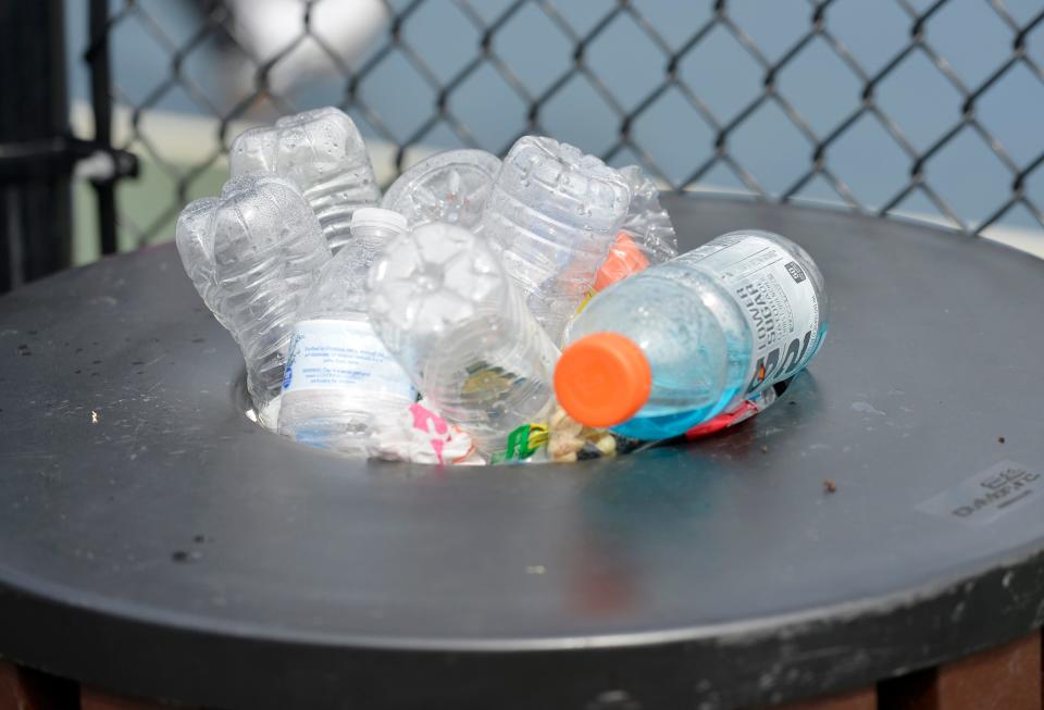 Plastic bottles overflow from a trash can at pickleball courts in Mashpee in this 2021 file photo.