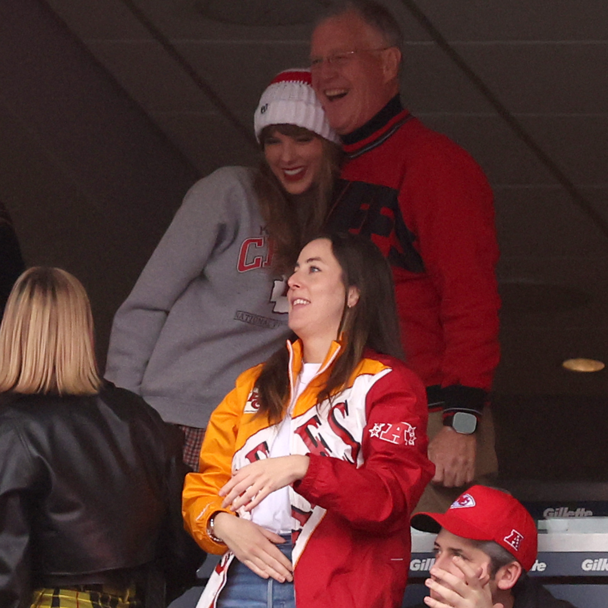   Brittany Mahomes looks on while Taylor Swift hugs Scott Kingsley Swift and Alana Haim cheers while the Kansas City Chiefs and the New England Patriots play. 