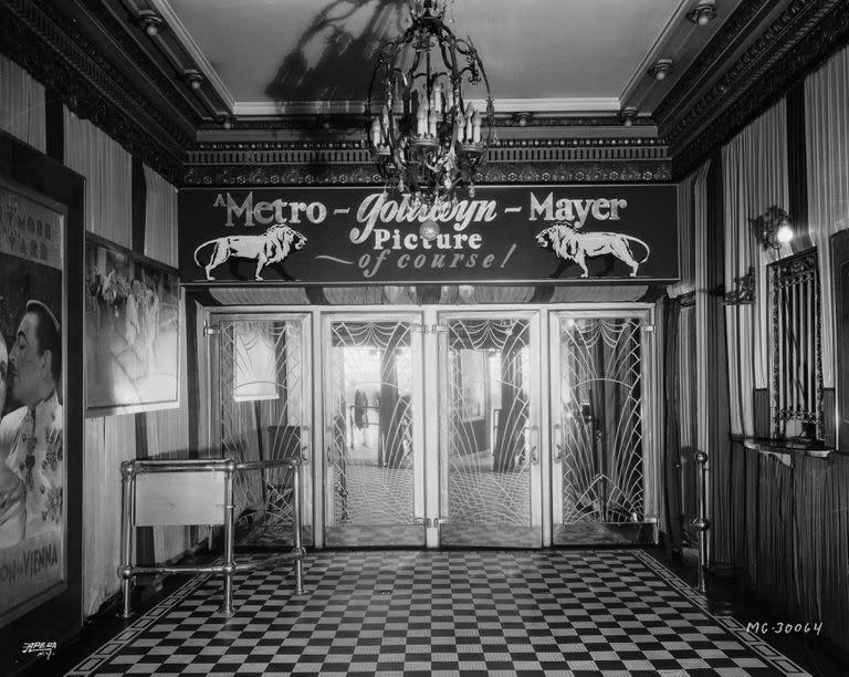 En 1933, cuando aún no se habían dividido los estudios de las exhibidoras en Hollywood, el foyer de un cine de MGM, adornado con el logotipo del león del estudio y las palabras "¡Una película de Metro-Goldwyn-Mayer, por supuesto!" (Foto a través de la Fundación John Kobal / Getty Images)