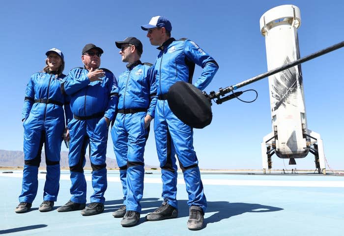 The four crew members standing on the landing pad after their flight