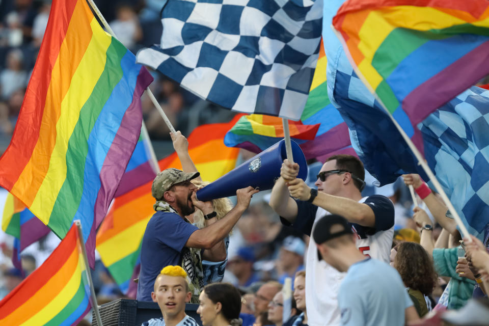 KANSAS CITY, KS - AUGUST 17: A Sporting Kansas City fan yells in a megaphone while flags fly around him during an MLS match between the San Jose Earthquakes and Sporting Kansas City on August 17, 2019 at Children's Mercy Park in Kansas City, KS.  (Photo by Scott Winters/Icon Sportswire via Getty Images)