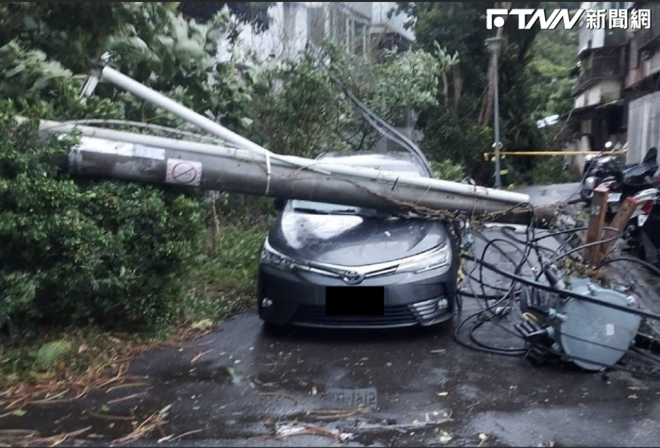 電線桿不敵強風倒塌，正好砸中下方的轎車。（圖／翻攝畫面）