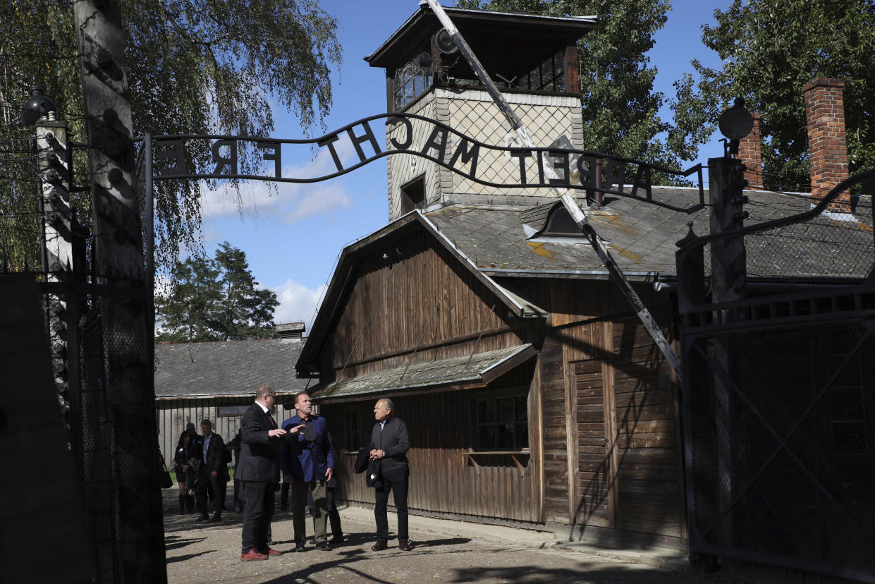 Arnold Schwarzenegger, center, and Simon Bergson, chairman of The Auschwitz Jewish Center Foundation, right, visit the Auschwitz - Birkenau Nazi German death camp in Oswiecim, Poland, Wednesday, Sept. 28, 2022. Film icon Arnold Schwarzenegger visited the site of the Nazi German death camp Auschwitz on Wednesday to send a message against hatred. The "Terminator" actor was given a tour of the site, viewing the barracks watchtowers and the remains of gas chambers that endure as evidence of the German extermination of Jews, Roma and others during World War II. (AP Photo/Michal Dyjuk)