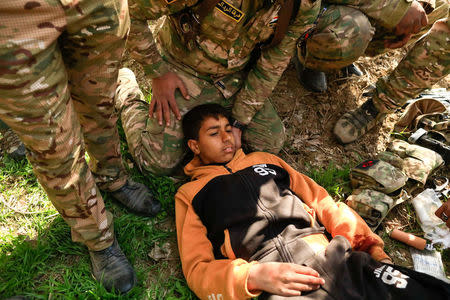 Rapid Response forces members surround an injured boy as they treat him during a battle with Islamic State's militants south west of Mosul, Iraq February 24, 2017. REUTERS/Zohra Bensemra