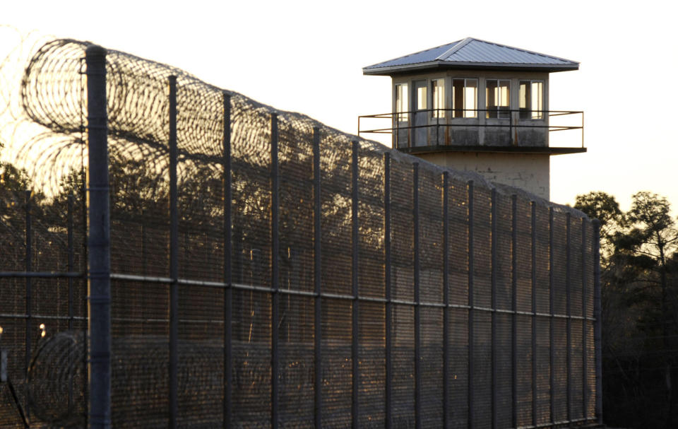 The sun sets behind Holman Prison in Atmore, Ala., on Thursday, Jan., 27, 2022, as the U.S. Supreme Court considered whether to allow the execution of death row inmate Matthew Reeves, convicted of killing a man during a robbery in 1996. (AP Photo/Jay Reeves)