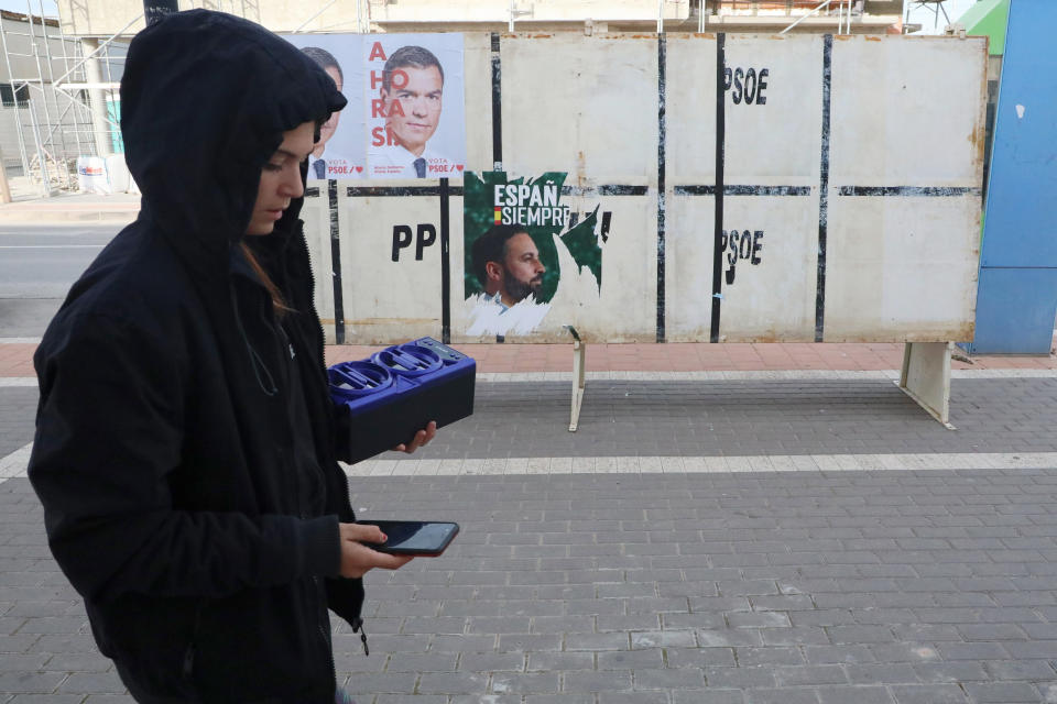 A girl walks in front of Spain's far-right Vox party candidate Santiago Abascal, right, and Spain's caretaker Prime Minister and socialist candidate Pedro Sanchez in Torre-Pacheco, Spain, Monday, Nov. 11, 2019. The Vox party has emerged as a political force in Spain by hyping the threat of migration and playing up Spanish nationalism in a country that has long thought of itself as being immune to the wave of populism sweeping Europe. (AP Photo/Sergio Rodrigo)