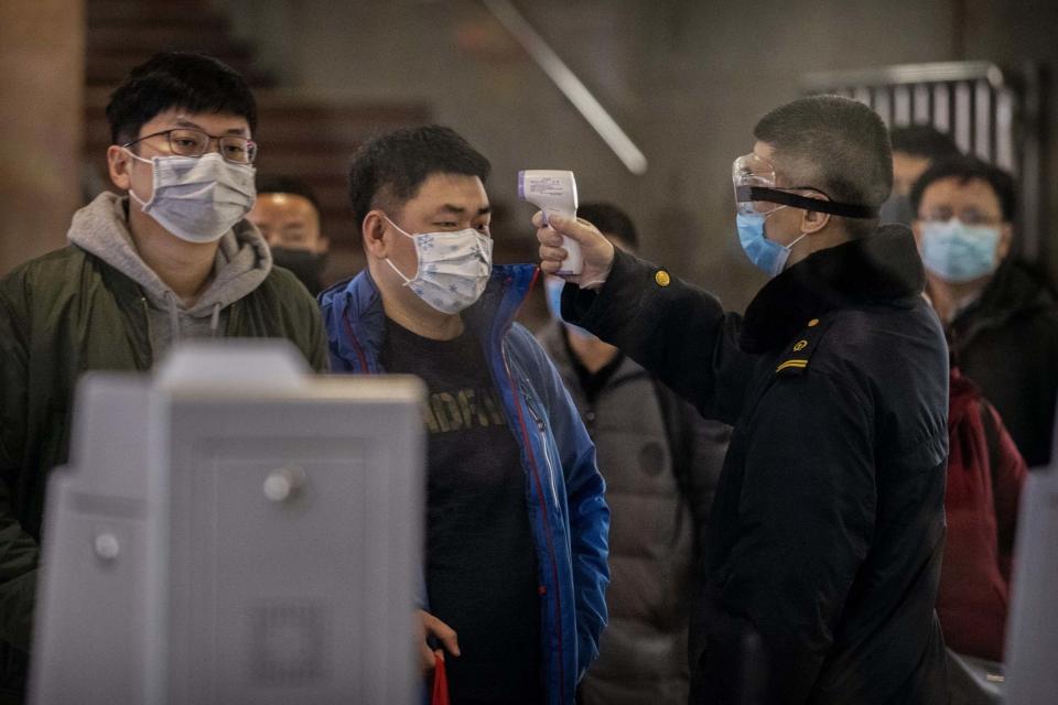 A Chinese passenger checked for a fever by a health worker at a Beijing railway station (Getty Images)