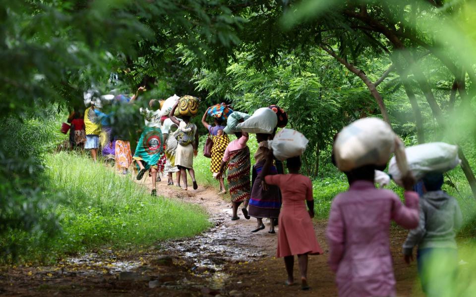 Flood victims from Mtauchira village carry food they received from the Malawi government in the aftermath of Cyclone Freddy that destroyed their homes in Blantyre, Malawi - ESA ALEXANDER/REUTERS