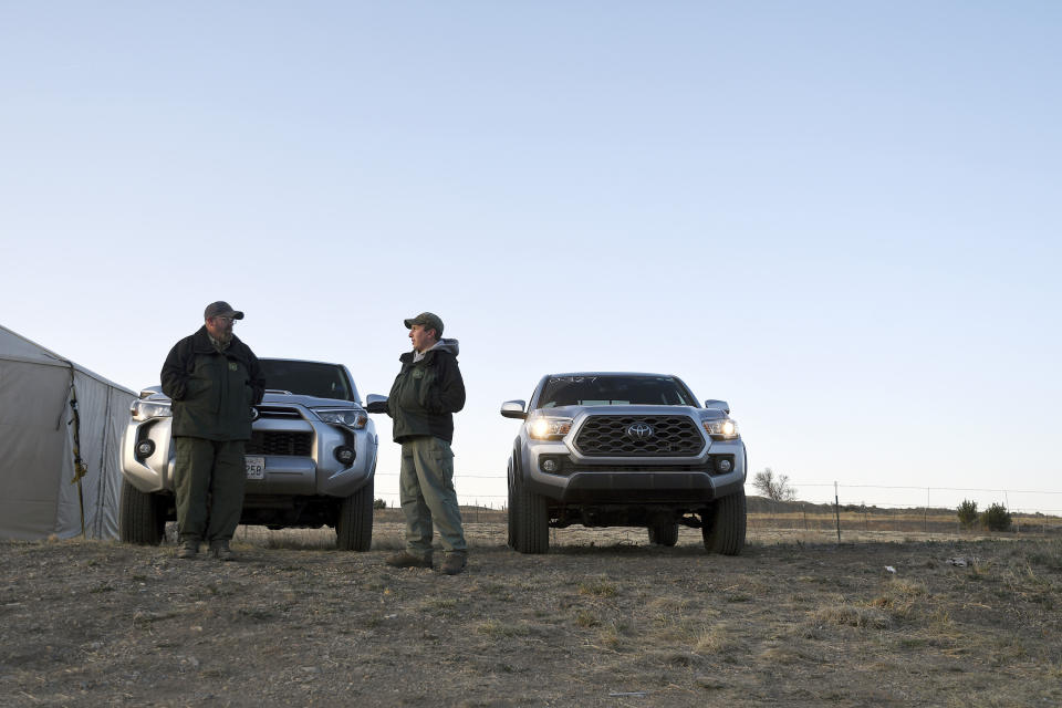 Security guards with the United States Forest Service stand at the entrance to a fire camp in Las Vegas, N.M., on Tuesday, May 3, 2022. (AP Photo/Thomas Peipert)