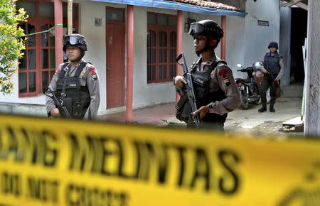 Armed police stand in front a house whose owner was arrested during a raid in the Langgen village in Tegal, Indonesia Central Java, January 15, 2016 in this photo taken by Antara Foto. REUTERS/Oky Lukmansyah/Antara Foto