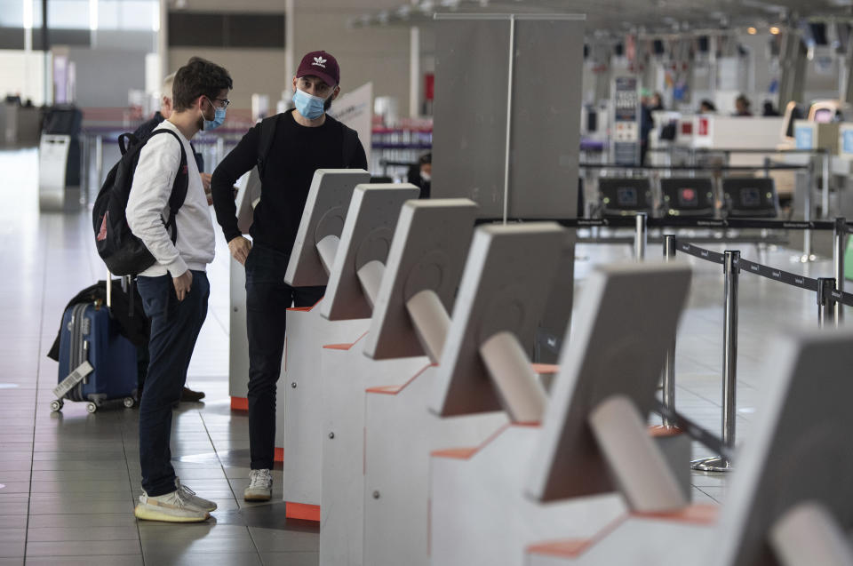 Passengers use a self check in machine for flights to Queensland at Sydney Domestic Airport, Sydney, Friday, July 31, 2020. Tourism operators across Asia and the Pacific are making furtive and faltering advances, as well as some spectacular missteps, after travel was largely halted by the coronavirus pandemic that continues ebbing and mostly surging around the globe. Struggling tourism businesses in Queensland, known as Australia’s Sunshine State, will soon lose visitors from the nation’s biggest city, Sydney. (James Gourley/AAP Image via AP)